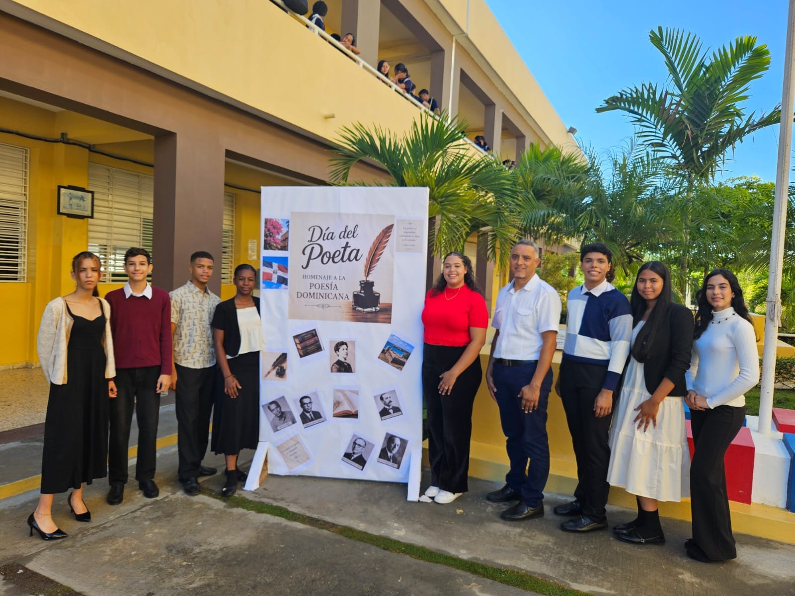 Estudiantes panelistas, docentes y maestra de ceremonias junto al mural Homenaje a la poesía dominicana