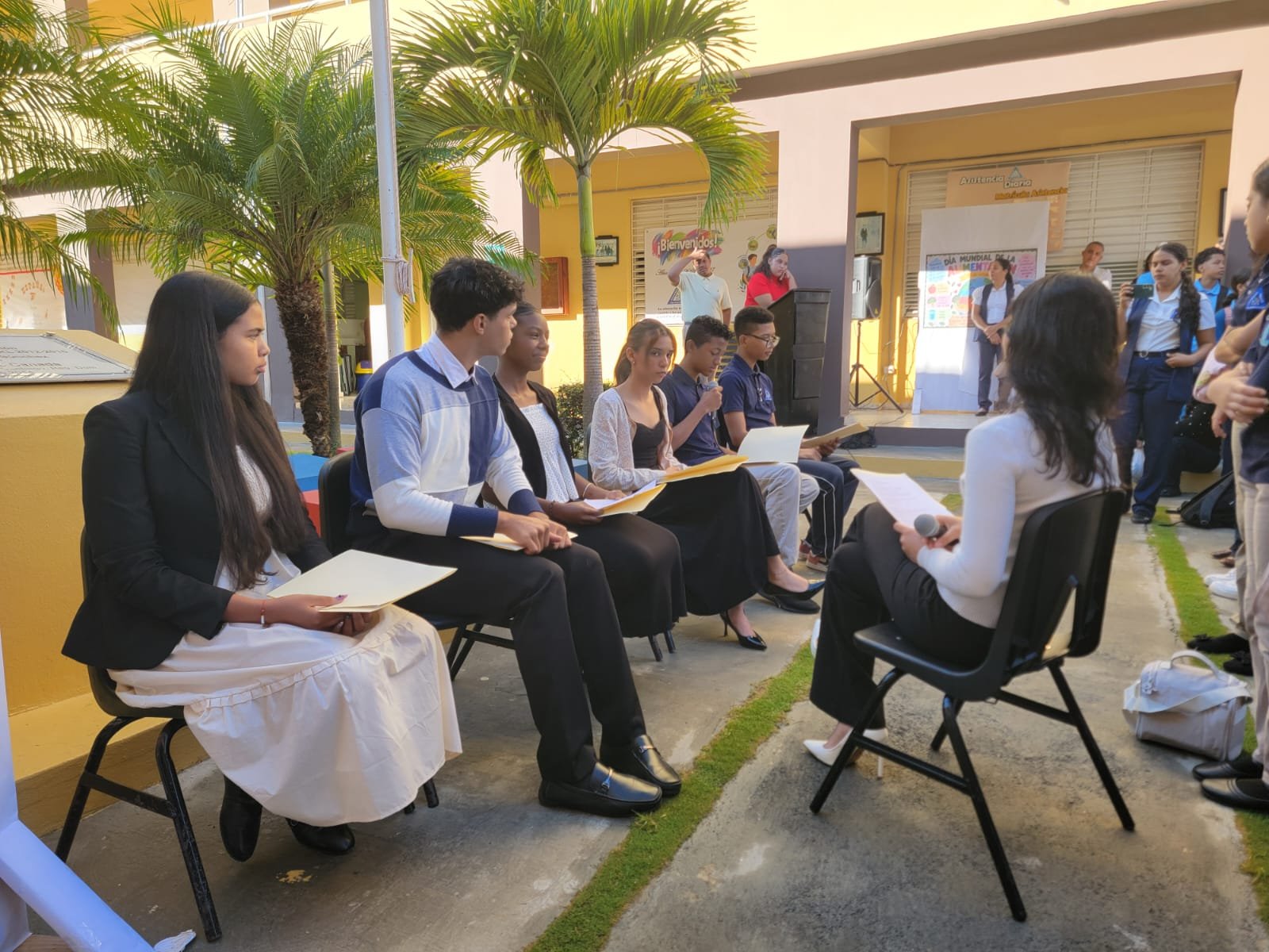 Estudiantes del panel Los poetas sentados con sus carpetas durante el acto