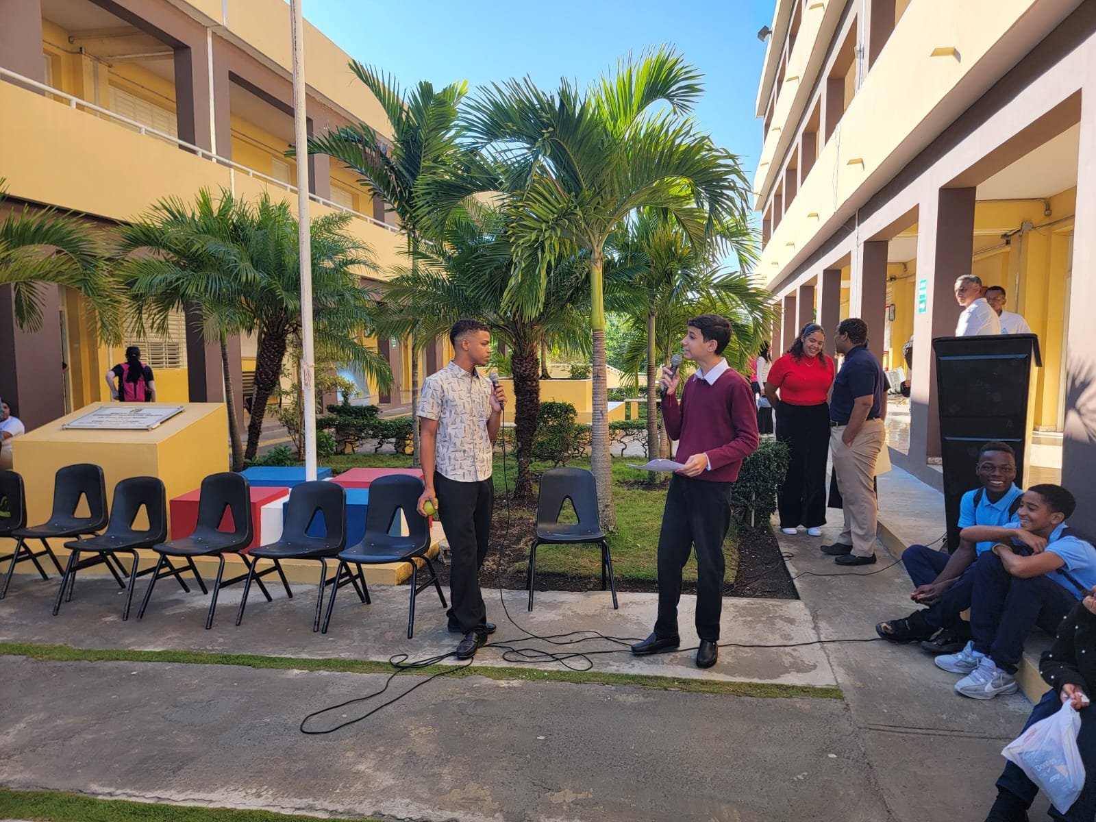 Dos estudiantes con micrófono presentan su participación en el acto