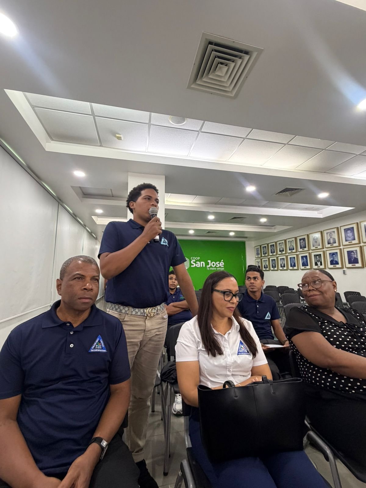 Un estudiante pasante comparte su experiencia ante docentes y empresas, en el salón de conferencias