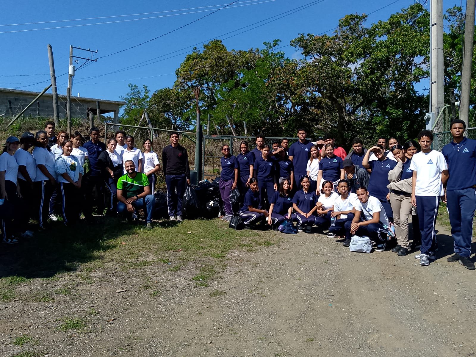 Grupo de estudiantes y docentes del Politécnico Canadá junto a las bolsas de basura recogidas en Botoncillo