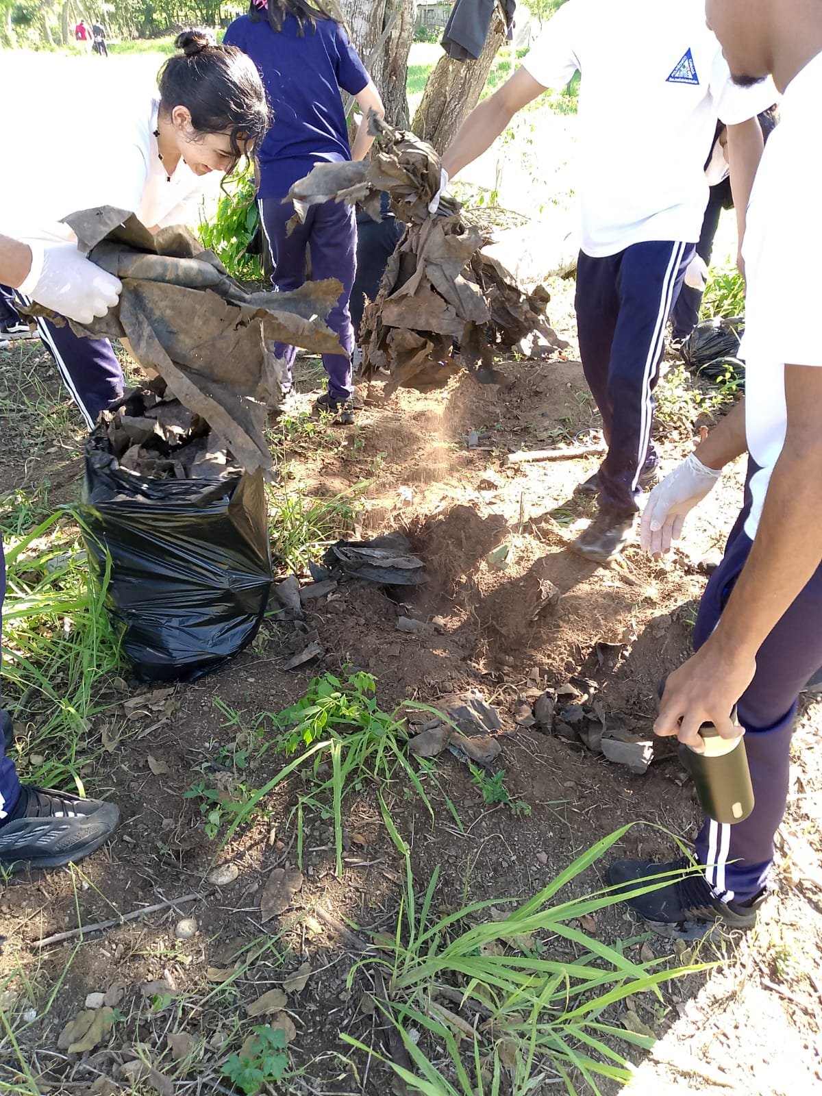 Estudiantes con guantes recogen residuos en la jornada de saneamiento