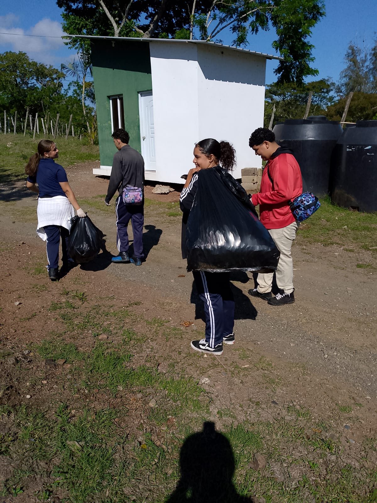 Estudiantes cargan bolsas de residuos durante la jornada