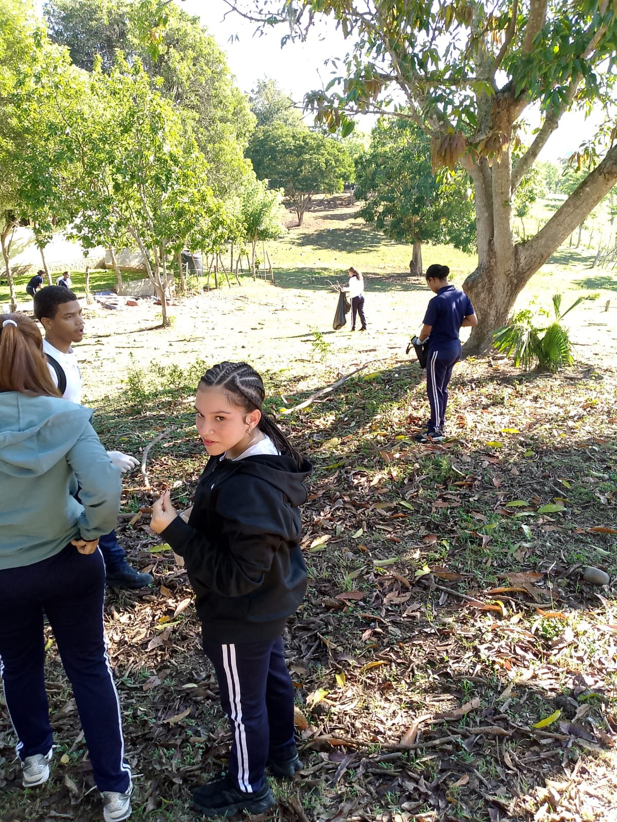 Estudiantes recorren un terreno de la comunidad para recoger residuos